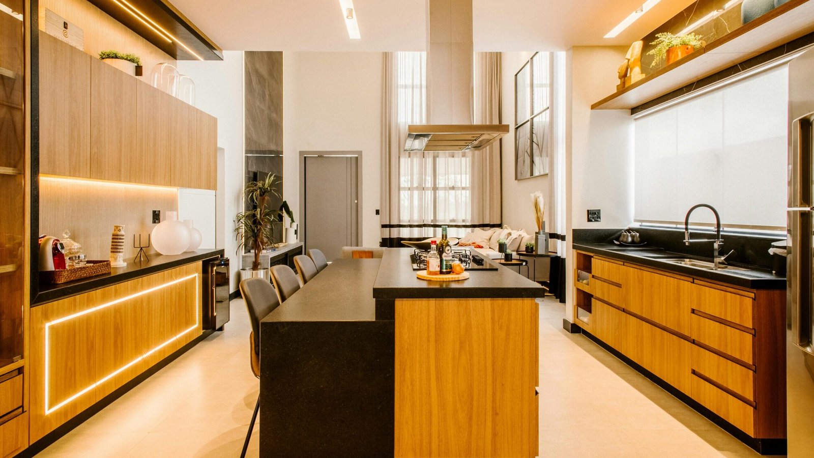 Functional Kitchen Layouts | Elegant contemporary kitchen with wood cabinets, black countertops, and warm lighting for a luxurious feel.