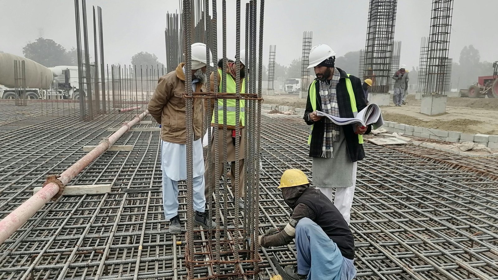 Seohara me Best Civil Engineer kaise choose karein? | Construction workers and engineers at a site in Bahāwalnagar, Punjab, Pakistan, inspecting metal framework.