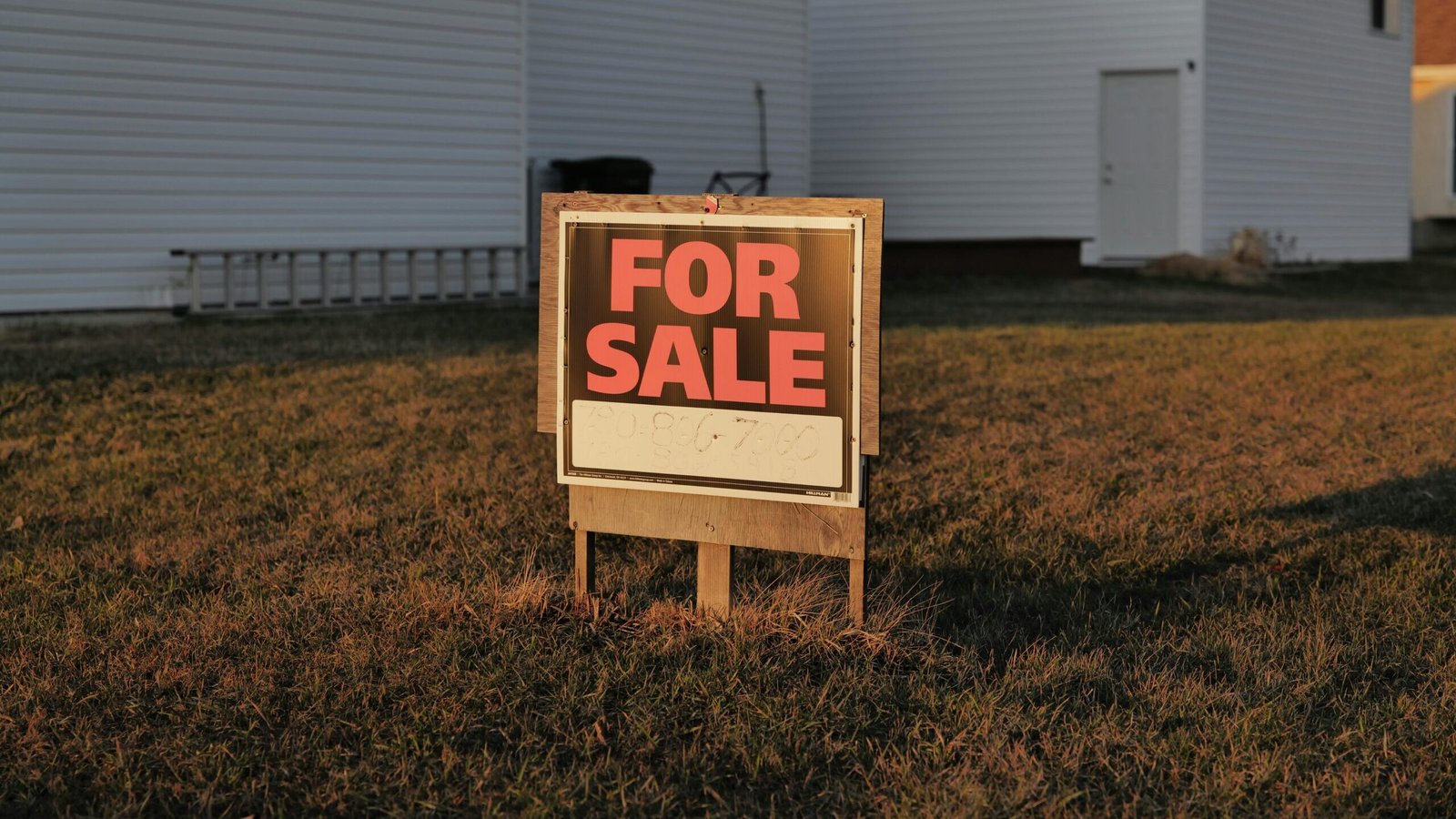 Property Buy/Sell karte waqt Kya Dhyan Rakhein? | Close-up of a 'For Sale' sign in a suburban yard, indicating a property for sale.