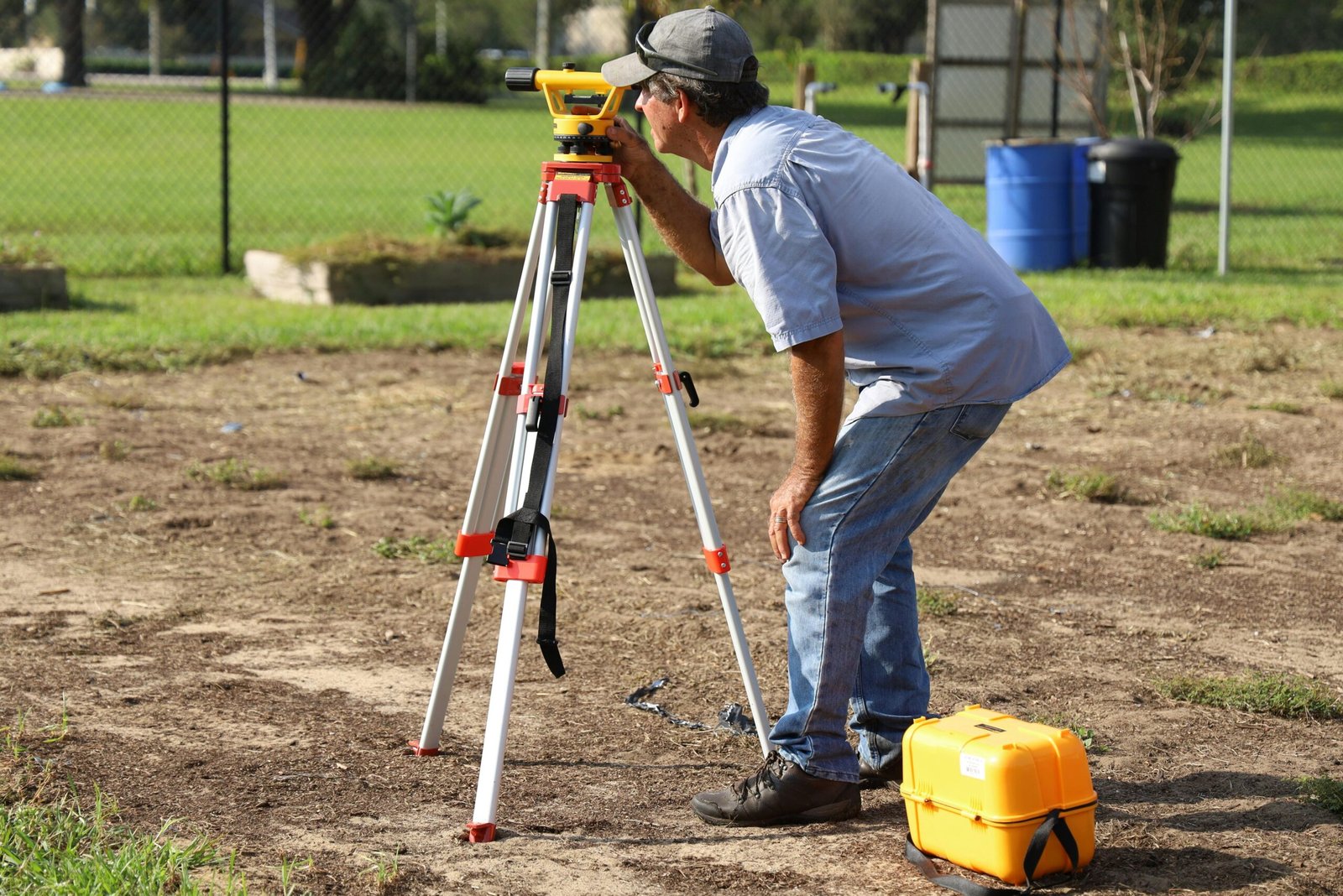 Property Measurements Guide: How to Measure a Plot Accurately | UA Map Studio Seohara, Dist- Bijnor | A land surveyor at work using equipment on a field in Tavares, Florida.