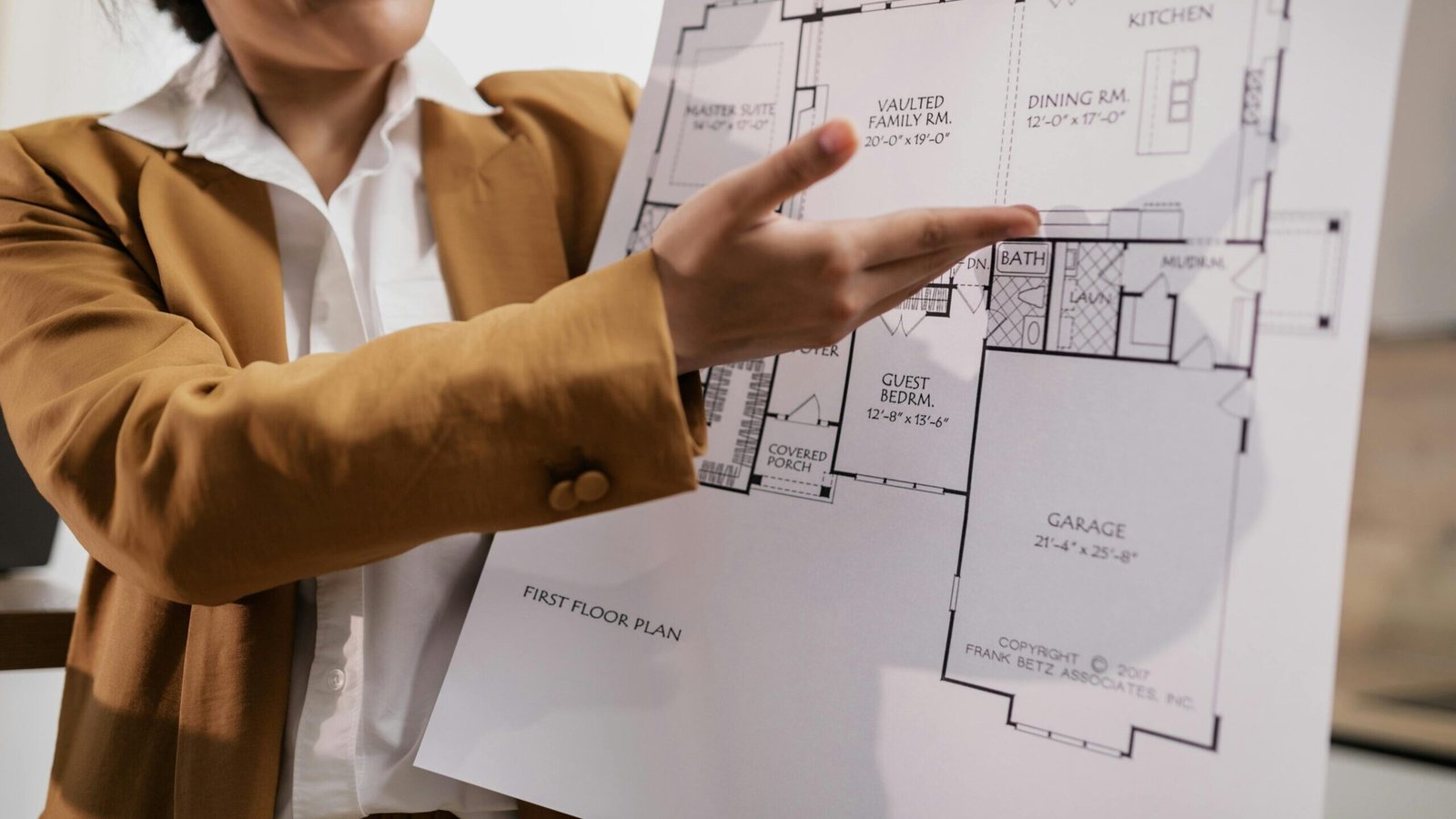Steps in Effective House Map Planning | A real estate agent showcases a detailed home floor plan for potential buyers.