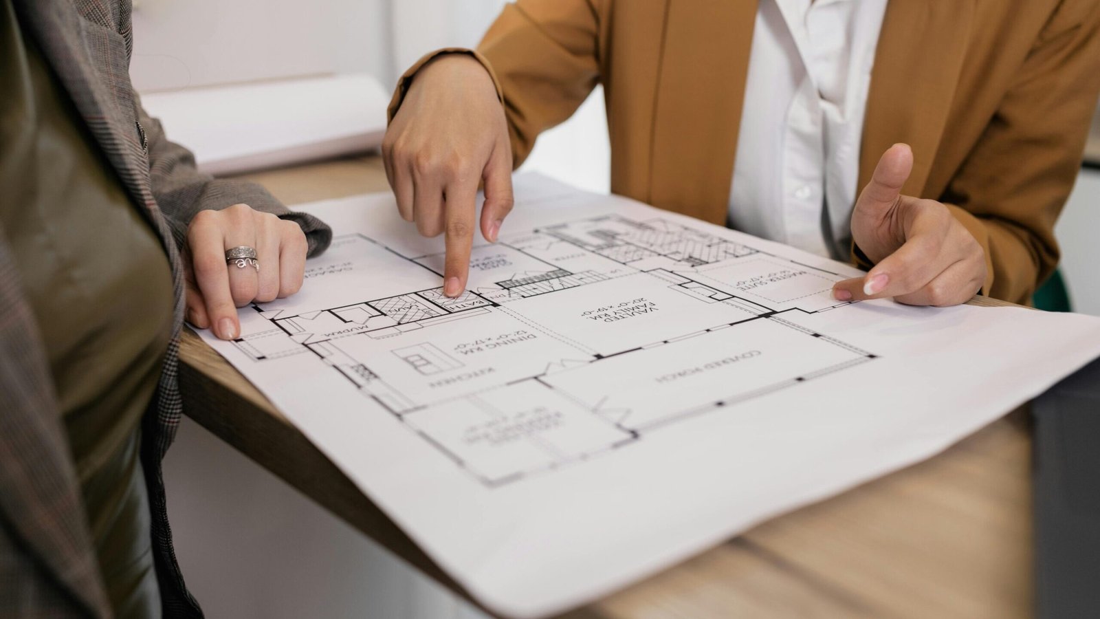  25x50 Plot House Plan Design 2026 : Best Layout Ideas, Parking + Rooms & Vastu Tips | UA Map Studio | Civil Engineer & Property Consultant in Seohara, District- Bijnor | |Two professionals reviewing architectural plans, focused on floor layout and design details.